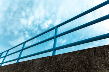 Blue steel railing abstract pattern of the bridge railing. metal construction, steel railing on the Highway bridge against blue sky