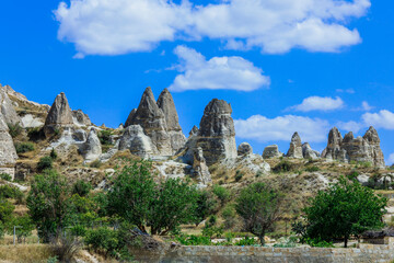 Fototapeta na wymiar Fantastic View to the Göreme with rock houses in front of the spectacularly coloured valleys nearby, Cappadocia, Turkey