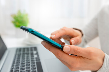 Woman's hands use mobile phone and laptop to shop online. Authentication in Internet banking on a...
