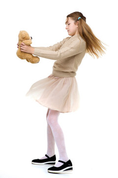 Preteen girl playing with teddy bear. Photo session in the studio