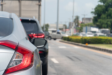 Luxury of gray car stop on the asphalt road by traffic light control in across. Traveling in the provinces during the bright period. Open light brake. On the right there is a blur of the lawn.