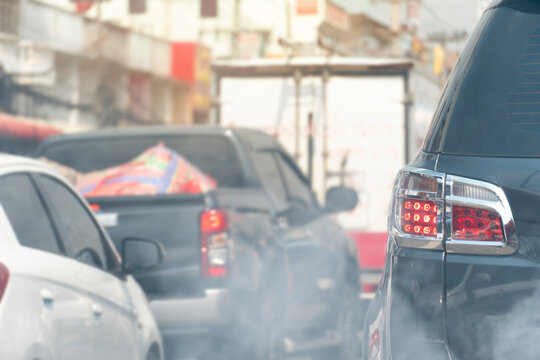 ฺBack side of the black car with open brake light. With traffic jams Along with the pollution environment with faint smoke in front of picture.