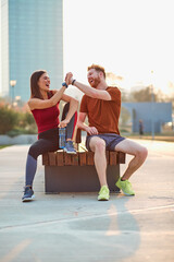 Two young sporty man and woman exercising in urban park.