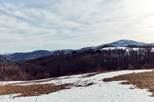 View from a mountain top with some snow on distant hills.