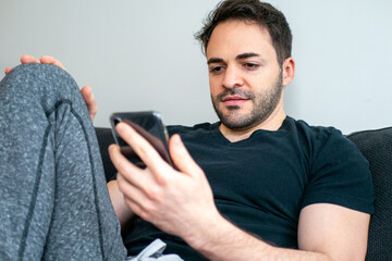 室内のソファーに座ってくつろぐ欧米の男性