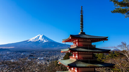 View on Chureito Pagoda and mountain of the mountains Mt Fuji, Japan, captured on a clear, sunny day in winter. Top of the volcano covered with snow. Trees aren't blossoming yet. Postcard from Japan.