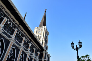 Church Roof with a cross. Church building roof with holy cross. Cloudy moody blue sky background. Minimal architecture design and detail. Exterior design and detail. Abstract architecture.