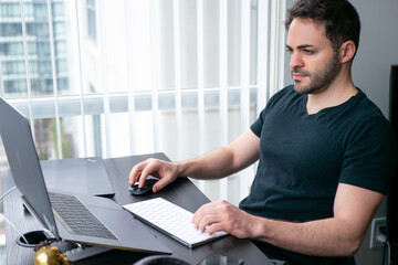 見晴らしのいい部屋で在宅ワークをする男性