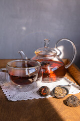 a cup of tea and a teapot, next to Chinese green oolong tea on the table