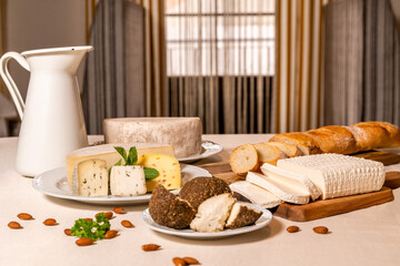 Homemade goat cheese and curd cheese are served for breakfast on a table with a linen tablecloth....