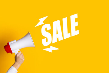 Female hand holding a megaphone on a yellow background. Added the text Sale. Hiring concept, help...