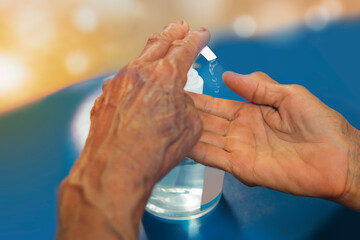 Close up hands of asian senior woman using alcohol gel for hands washing, with hand sanitizer to avoid contaminating with Coronavirus