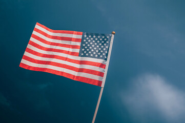 American flag, on against a overcast sky.