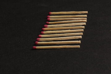 A row of matches with red heads isolated on a black background