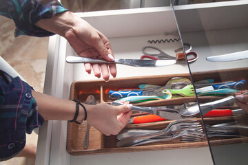 Woman hand holding knife in kitchen.
