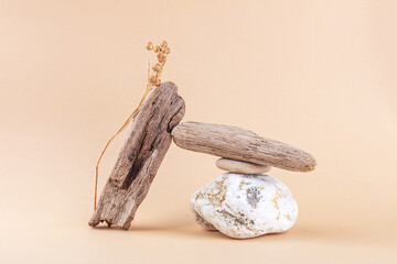 Balance and harmony. Natural composition of stones, driftwood and flax plant on neutral beige background. Copy space.