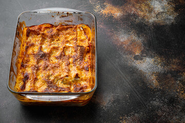 Italian Food. Hot Tasty Freshly Baked Lasagna, in baking tray, on old dark rustic background, with copy space for text