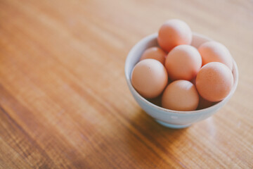Brown eggs on a bowl. Eggs on wood table. Baking with eggs. 