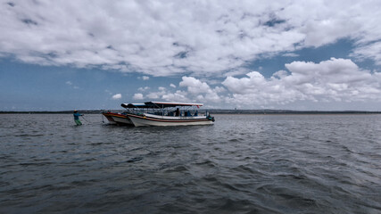 silhouette of a boatman pulling his ship in the middle of the low tide in the afternoon for tourism campaigns, vacation spots and design needs