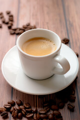 Cup of hot coffee on wooden table, surrounded by coffee beans
