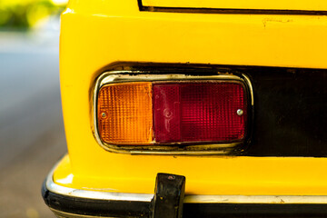 Taillight details of an antique car in yellow