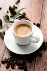Cup of hot coffee on wooden table, surrounded by coffee beans