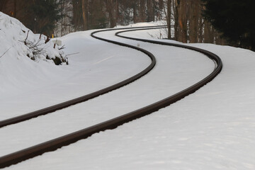 Fototapeta na wymiar railway tracks in snowy forest, lines meandering