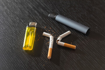 Naklejka premium Electronic smoke device and cigarette on black background. Quit smoking concept.