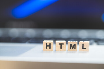 HTML web language: Wooden cubes with letters “HTML” lying on a laptop, concept for HTML