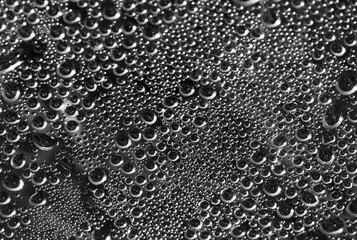 Drops of water on a black surface. The condensate. Top view. Free space.