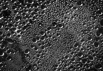 Drops of water on a black surface. The condensate. Top view. Free space.