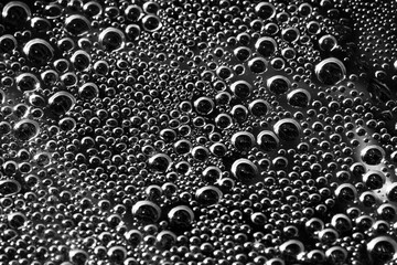 Drops of water on a black surface. The condensate. Top view. Free space.