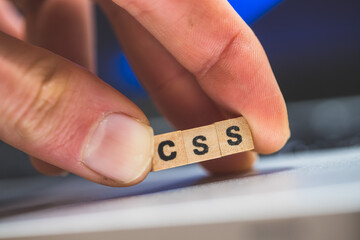 CSS web language: Wooden cubes with letters “CSS” lying on a laptop, concept for style sheet...