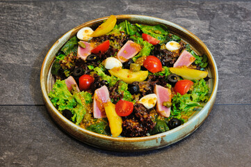 Delicious, beautiful, fresh salad in a plate on a wooden restaurant table