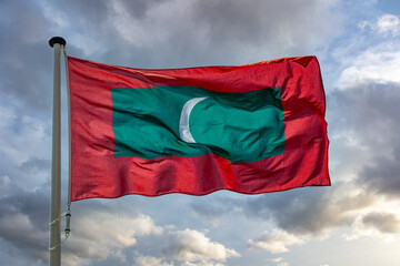 Fototapeta na wymiar Maldives flag waving against cloudy sky