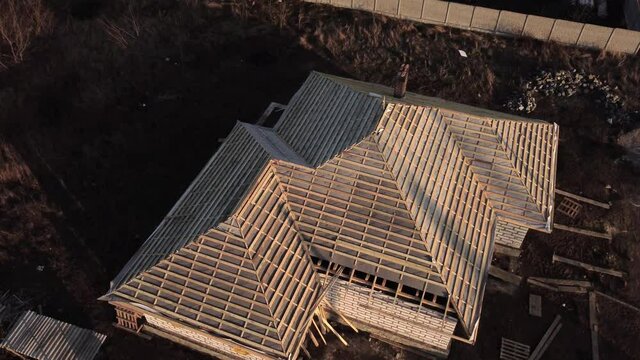 Aerial view of unfinished brick house with  structure under construction.