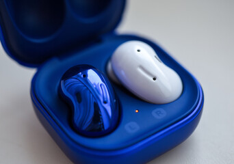 Wireless lost headphones of different colors in a case on a white background