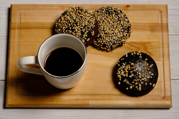 white coffee cup with three cakes on a wooden cutting board