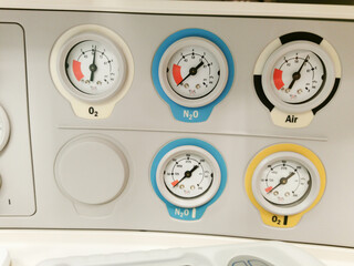 Gas pressure analog manometer gauges on anesthetic machine: oxygen, laughing gas, air.