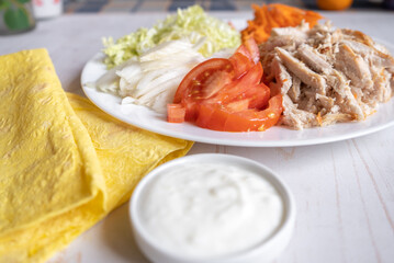 Shaurma, burrito, chicken roll or pita with chicken, fresh vegetables, cream sauce and corn flour lavash