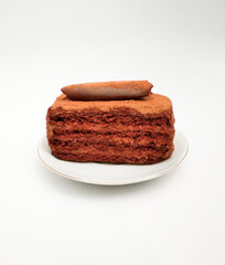 dark chocolate ganache cake layer cake over buttercream on white plate.