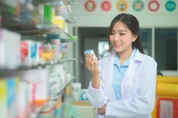 Portrait of asian woman pharmacist wearing lab coat in a modern pharmacy drugstore.