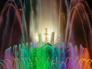 Long exposure photography of colorful fountain sprays in blue, green, pink neon illumination. Water rainbow. Bright night in the Moscow public park. High resolution image.