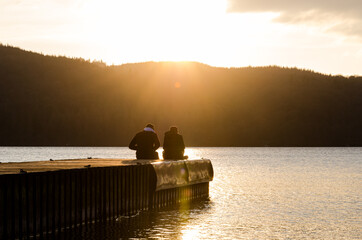 Obraz na płótnie Canvas Couple at sunset at lake Windermere.