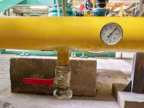 Industrial thermometer on the system pipe. Gauges on yellow sludge pipe i