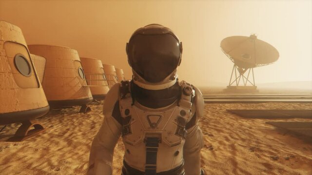 Astronaut on the planet Mars, making a detour around his base. Astronaut walking along the base. Small dust storm. The satellite dish sends data to the ground. Realistic 3D animation