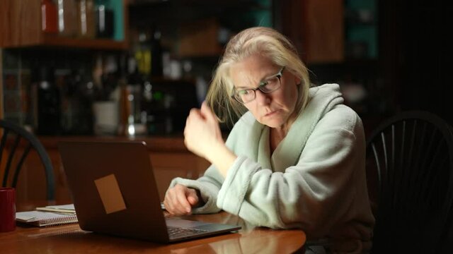 Serious mature woman calculating bills, taxes, checking finances manage personal finances seated at table at home, senior retired female worried about loan, bankruptcy, financial troubles concept