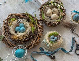 Pastel three colored easter eggs in the nest with cuckooflower in the background isolated on white