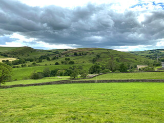 Obraz premium Landscape view from, Standsfield Brow, with fields, distant meadows, and hills, on a cloudy day in, Lothersdale, Keighley, UK