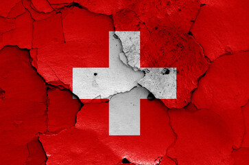 flag of Switzerland painted on cracked wall